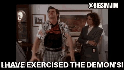 A Man Is Standing In A Living Room With His Arms Outstretched And A Woman Standing Behind Him . GIF