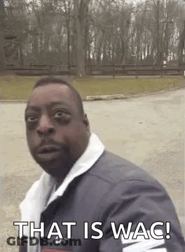 A Man Is Standing In A Parking Lot And Making A Funny Face With The Words `` That Is Wac '' . GIF