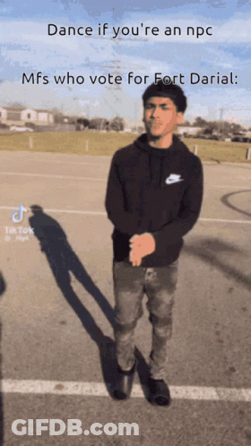 A Man Is Standing In A Parking Lot With The Caption Dance If You 'Re An Npc GIF