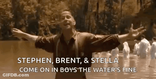 A Man Is Standing In A River With His Arms Outstretched . GIF