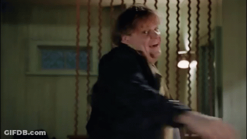A Man Is Standing In A Room With A Curtain Behind Him And A Person Is Holding His Arm . GIF