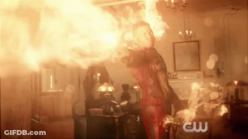 A Man Is Standing In A Room With A Lot Of Fire Coming Out Of His Hands . GIF