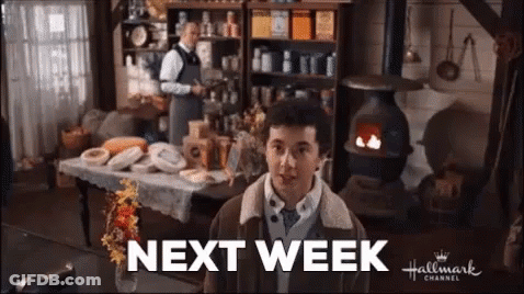 A Man Is Standing In A Room With A Sign That Says Next Week On It . GIF