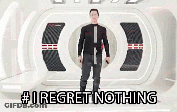 A Man Is Standing In A Room With The Words # I Regret Nothing On The Bottom . GIF