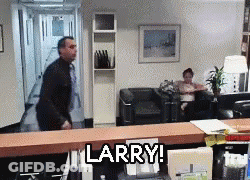 A Man Is Standing In A Waiting Room With The Words Larry On The Counter GIF