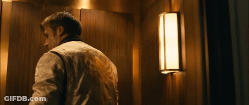 A Man Is Standing In An Elevator With A Light On The Wall GIF