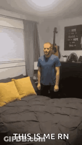 A Man Is Standing In Front Of A Bed With The Words This Is Me Rn On The Bottom GIF