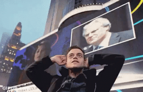 A Man Is Standing In Front Of A Billboard With His Hands On His Head . GIF