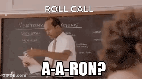 A Man Is Standing In Front Of A Blackboard In A Classroom And Giving A Lecture . GIF