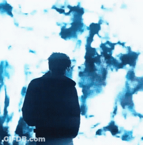 A Man Is Standing In Front Of A Blue Background GIF