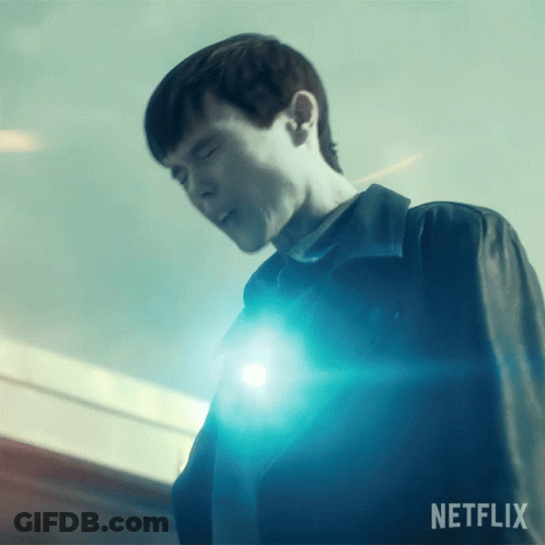 A Man Is Standing In Front Of A Blue Light And The Word Netflix Is On The Bottom GIF