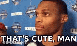 A Man Is Standing In Front Of A Blue Wall With The Words `` That 'S Cute , Man '' . GIF