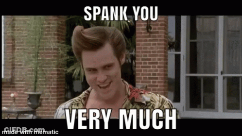 A Man Is Standing In Front Of A Brick Building With The Words `` Spank You Very Much '' Written On It . GIF