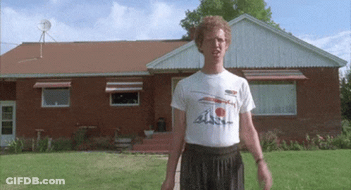 A Man Is Standing In Front Of A Brick House Wearing A T-Shirt That Says ' A ' On It GIF