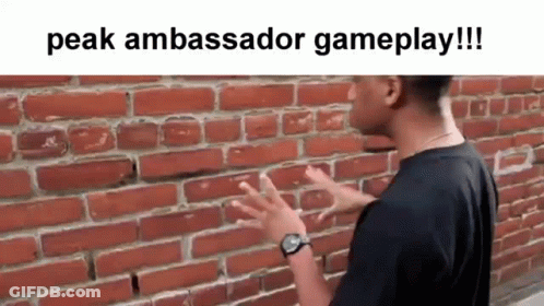 A Man Is Standing In Front Of A Brick Wall Talking To It . GIF