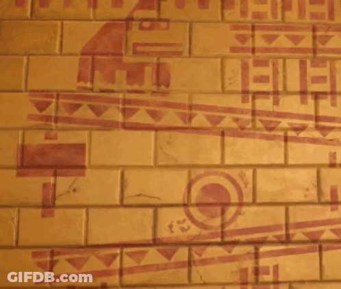 A Man Is Standing In Front Of A Brick Wall With A Drawing Of A Bird On It GIF