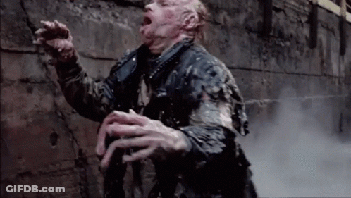A Man Is Standing In Front Of A Brick Wall With His Mouth Open And Smoke Coming Out Of His Mouth . GIF
