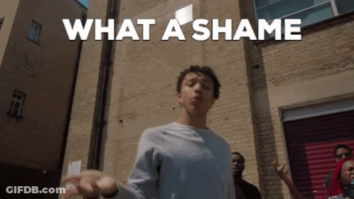A Man Is Standing In Front Of A Brick Wall With The Words What A Shame Written Above Him GIF