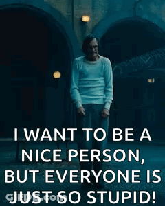 A Man Is Standing In Front Of A Building And Smoking A Cigarette . GIF