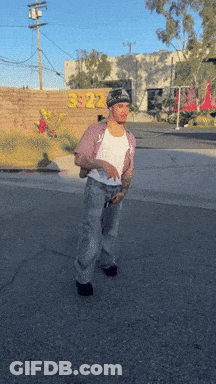 A Man Is Standing In Front Of A Building That Has The Number 3922 On It GIF