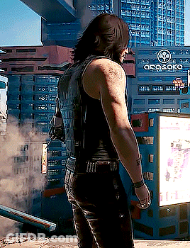 A Man Is Standing In Front Of A Building That Has The Word Osaka On It GIF