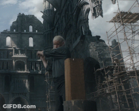 A Man Is Standing In Front Of A Building With Scaffolding In Front Of It GIF