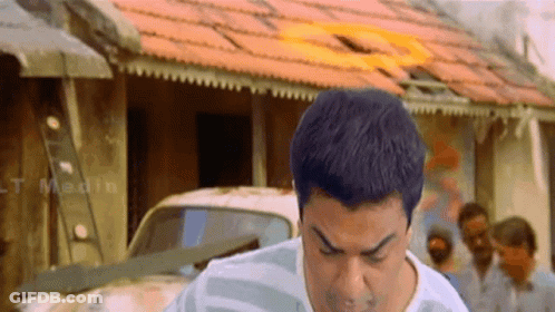 A Man Is Standing In Front Of A Building With The Word Medin On It GIF