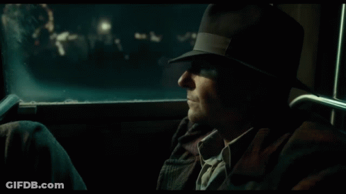 A Man Is Standing In Front Of A Cafe At Night GIF