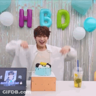 A Man Is Standing In Front Of A Cake And Balloons . GIF