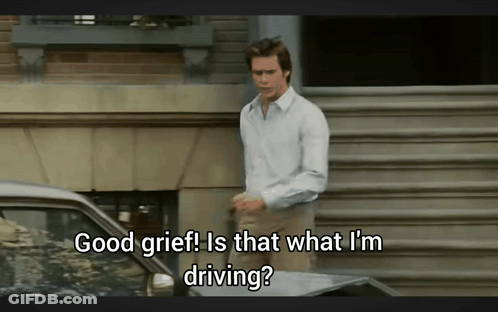 A Man Is Standing In Front Of A Car With The Words Good Grief Is That What I 'M Driving GIF