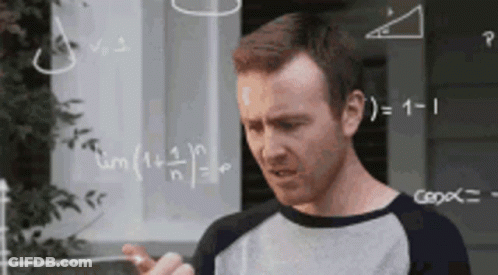 A Man Is Standing In Front Of A Chalkboard With Math Problems On It . GIF