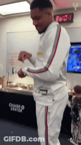 A Man Is Standing In Front Of A Chase Center Sign GIF