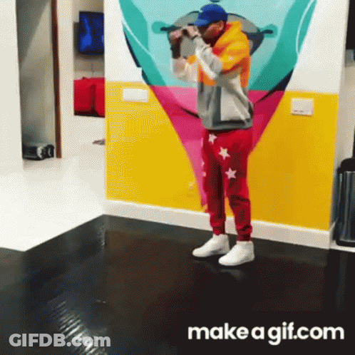 A Man Is Standing In Front Of A Colorful Wall With A Make A Gif.com Logo GIF
