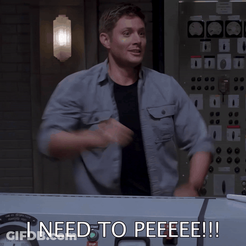 A Man Is Standing In Front Of A Control Panel With The Words Ineed To Peeeee Written On It GIF
