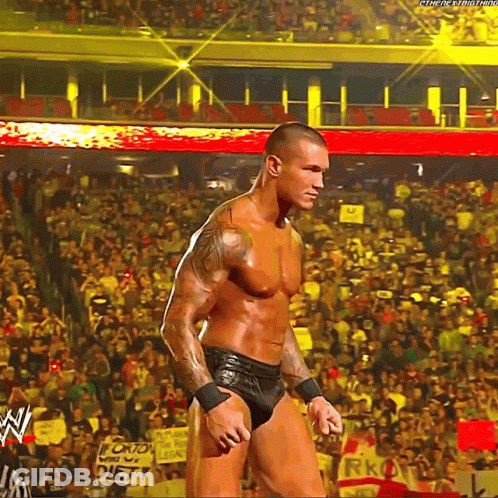 A Man Is Standing In Front Of A Crowd In A Stadium With A Sign That Says Diet On It . GIF