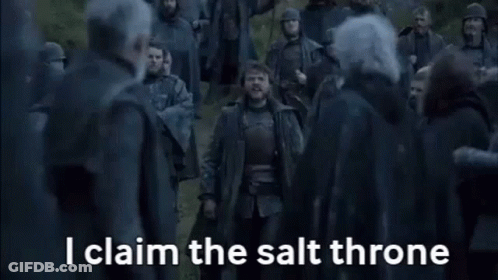 A Man Is Standing In Front Of A Crowd Of People And Yelling . GIF