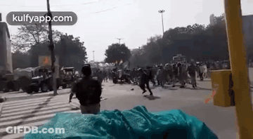 A Man Is Standing In Front Of A Crowd Of People On A City Street . GIF