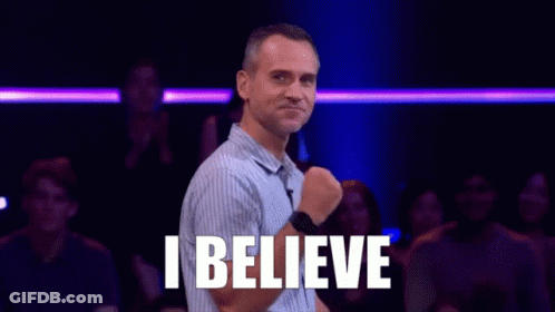 A Man Is Standing In Front Of A Crowd With The Words `` I Believe '' Written On His Chest . GIF