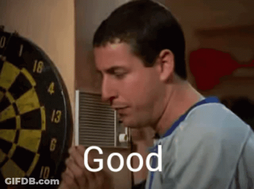 A Man Is Standing In Front Of A Dart Board With The Word Good Written On It GIF