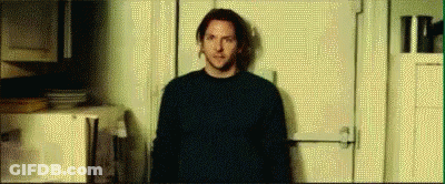 A Man Is Standing In Front Of A Door In A Room . GIF