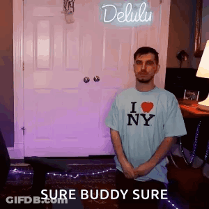 A Man Is Standing In Front Of A Door Wearing A I Love Ny Shirt . GIF