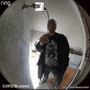 A Man Is Standing In Front Of A Door With A Ring Logo On It GIF