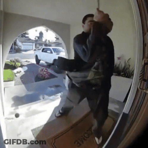 A Man Is Standing In Front Of A Door With A Welcome Mat On It GIF