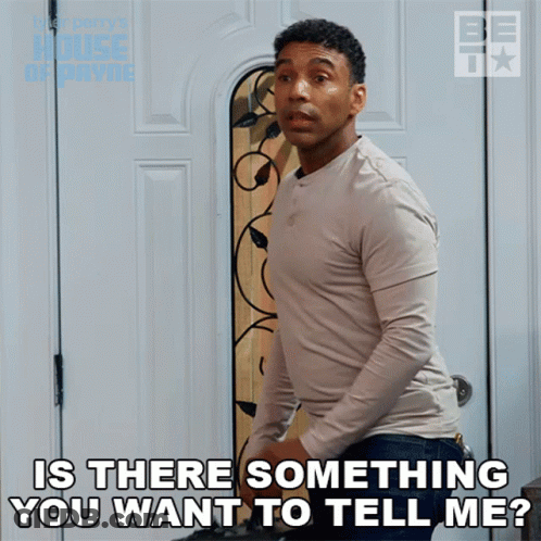 A Man Is Standing In Front Of A Door With The Words Is There Something You Want To Tell Me GIF