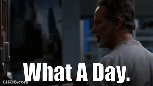 A Man Is Standing In Front Of A Door With The Words What A Day Written On It . GIF
