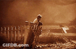 A Man Is Standing In Front Of A Fence In A Sepia Toned Photo GIF