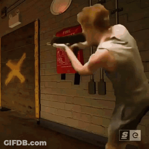 A Man Is Standing In Front Of A Fire Blanket Sign GIF