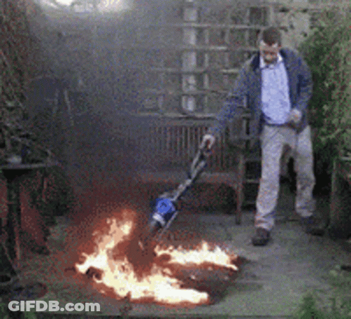 A Man Is Standing In Front Of A Fire Pit GIF