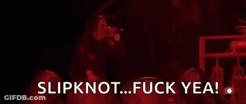 A Man Is Standing In Front Of A Fire With The Words Slipknot Fuck Yea GIF