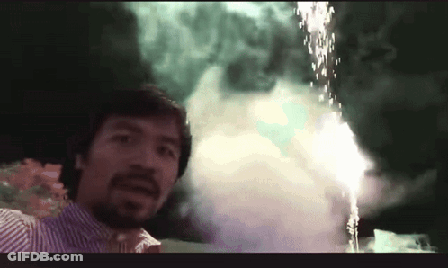 A Man Is Standing In Front Of A Fireworks Display GIF